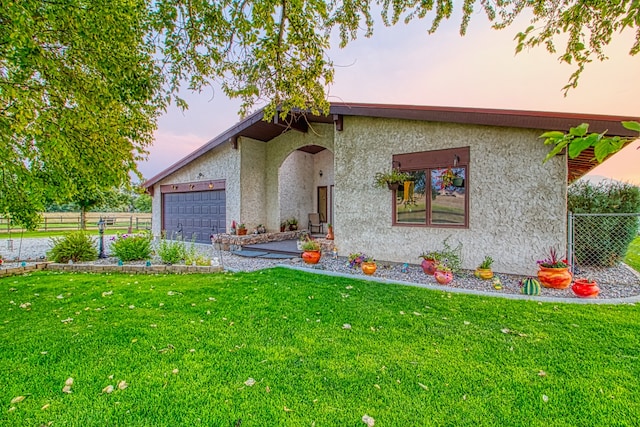 view of front of home with a garage and a yard