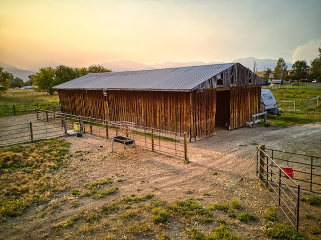 view of horse barn featuring a mountain view and a rural view