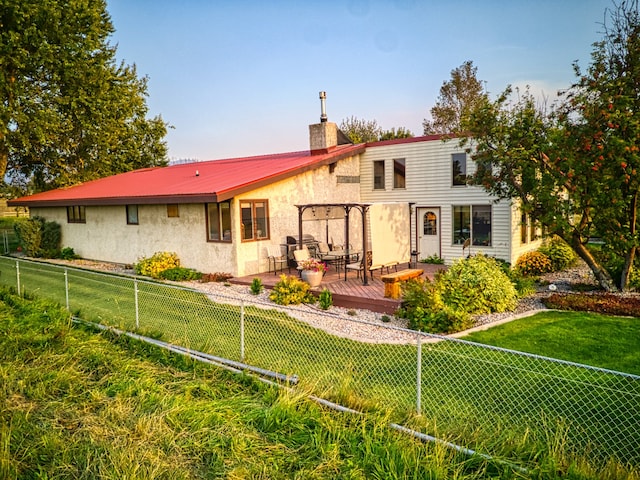 back of house featuring a lawn and a wooden deck