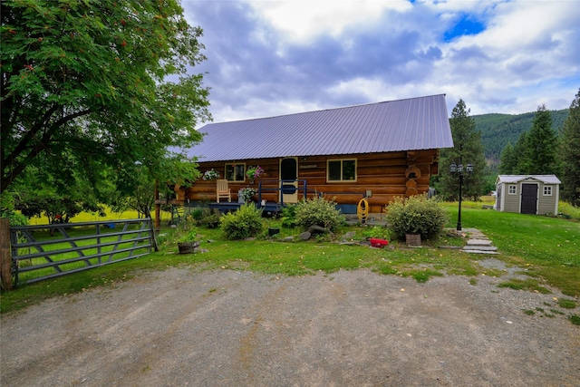 510 Johnson Ln, Superior, MT 59872 - view of front of property with a storage shed, an outbuilding, a front yard, log siding, and metal roof