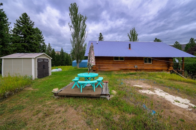 510 Johnson Ln, Superior, MT 59872 - back of house featuring log siding, a storage unit, an outdoor structure, a yard, and metal roof