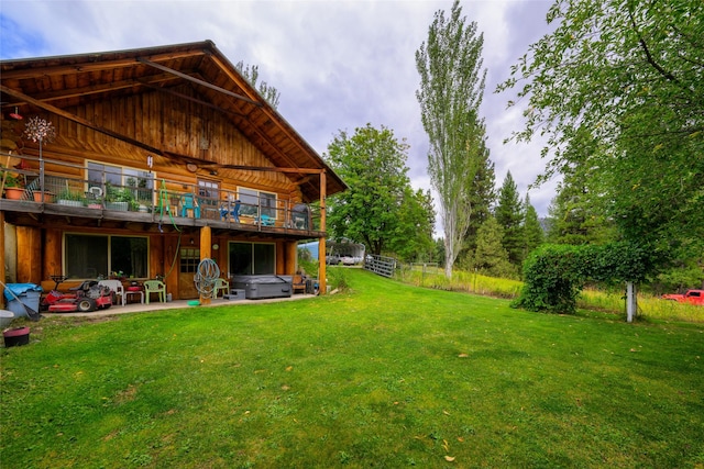 510 Johnson Ln, Superior, MT 59872 - rear view of house featuring a lawn, a patio area, a hot tub, board and batten siding, and log siding