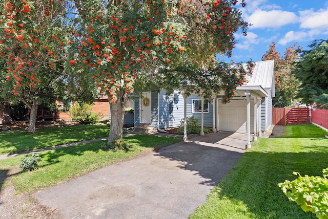 view of property hidden behind natural elements featuring a front yard and a garage