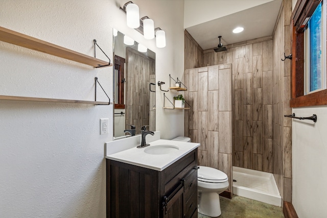 bathroom featuring vanity, toilet, and tiled shower