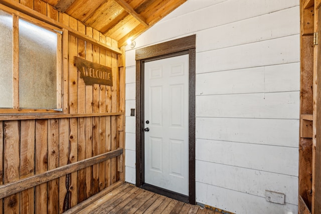 interior space with wood ceiling, lofted ceiling, hardwood / wood-style flooring, and wood walls