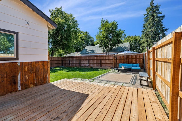 wooden deck featuring an outdoor hangout area, a lawn, and a patio