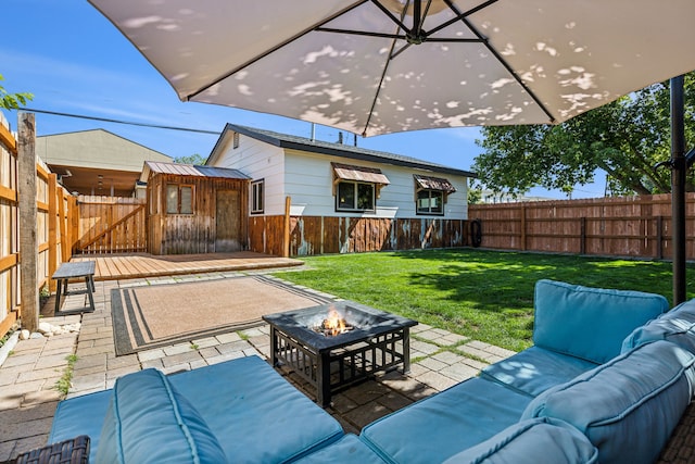 view of patio with an outdoor living space with a fire pit and a storage shed