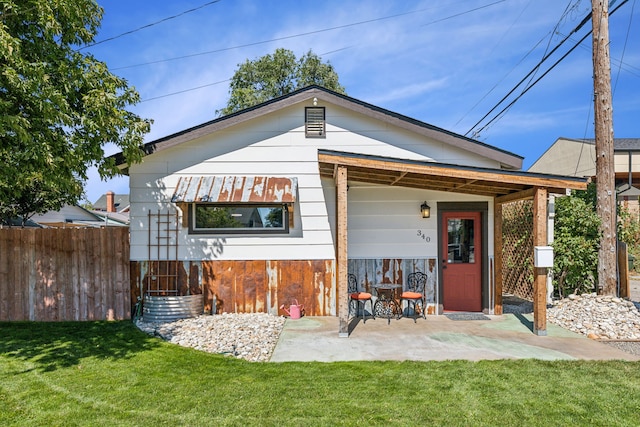 back of property featuring a yard and a patio