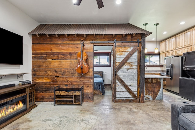 living room with plenty of natural light, ceiling fan, and a barn door