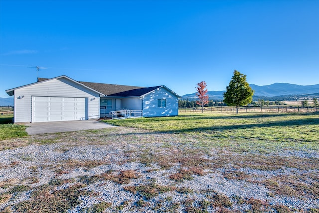 view of front facade featuring a rural view, a mountain view, and a front lawn