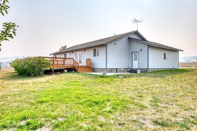 rear view of property with a wooden deck and a yard