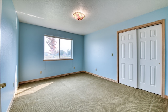 unfurnished bedroom featuring a textured ceiling, light carpet, and a closet