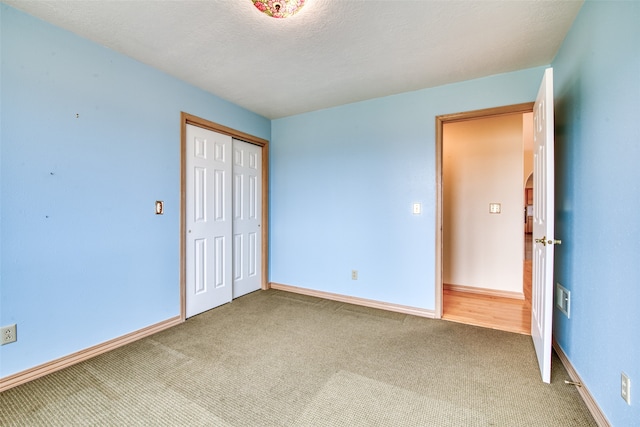 unfurnished bedroom featuring a textured ceiling, a closet, and carpet