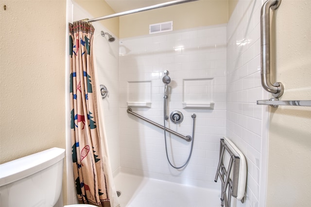 bathroom featuring toilet and a shower with shower curtain