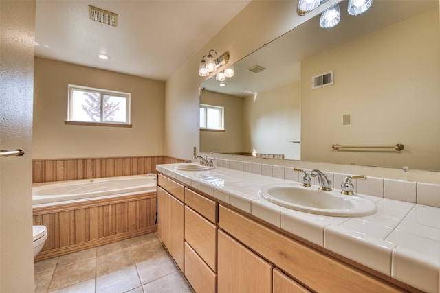 bathroom featuring a bathtub, vanity, toilet, and tile patterned floors