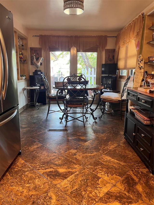 dining area featuring stone finish floor and built in features