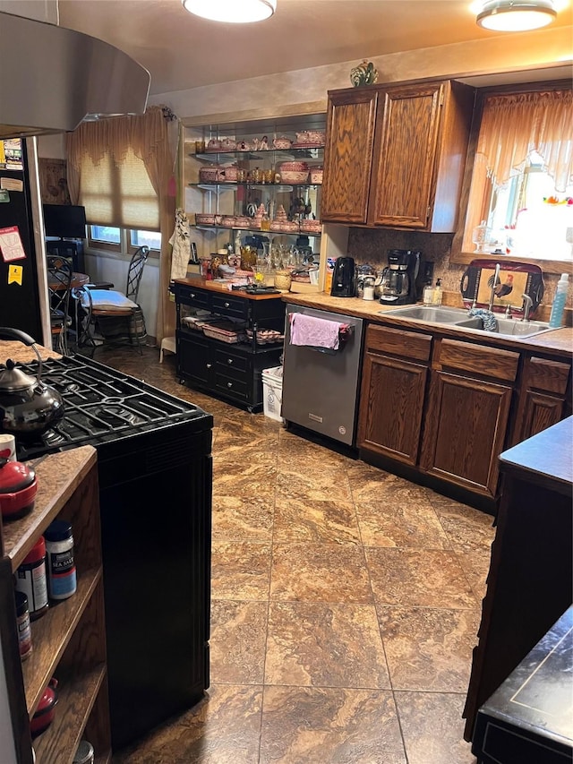 kitchen featuring open shelves, stainless steel dishwasher, freestanding refrigerator, black range with gas cooktop, and a sink