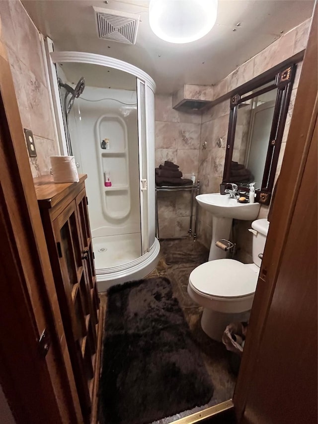 full bathroom with a stall shower, visible vents, toilet, marble finish floor, and tile walls