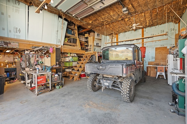 garage featuring white refrigerator, a workshop area, and a garage door opener