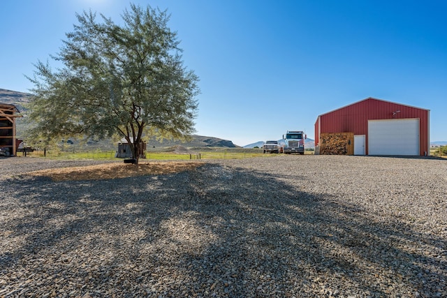 view of yard featuring an outbuilding, a garage, and a mountain view