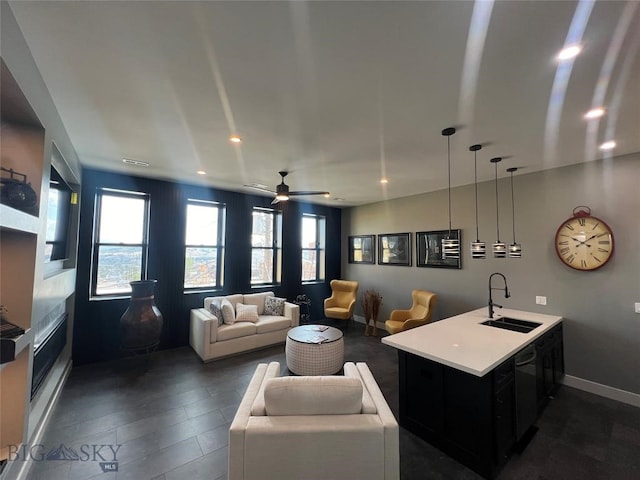 living room featuring dark wood-type flooring, sink, and ceiling fan