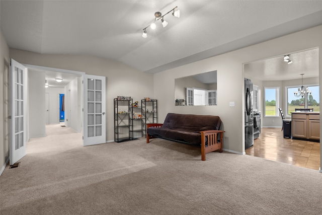 living area with lofted ceiling, french doors, and light carpet