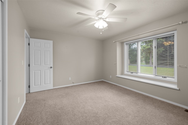 empty room featuring light carpet and ceiling fan