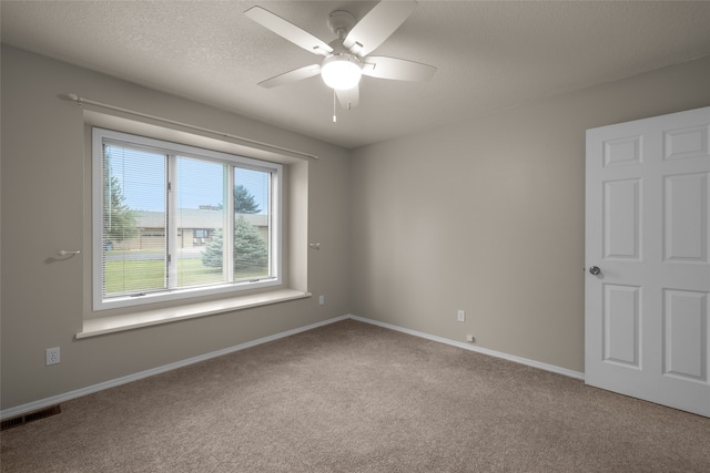 carpeted empty room with ceiling fan and a textured ceiling