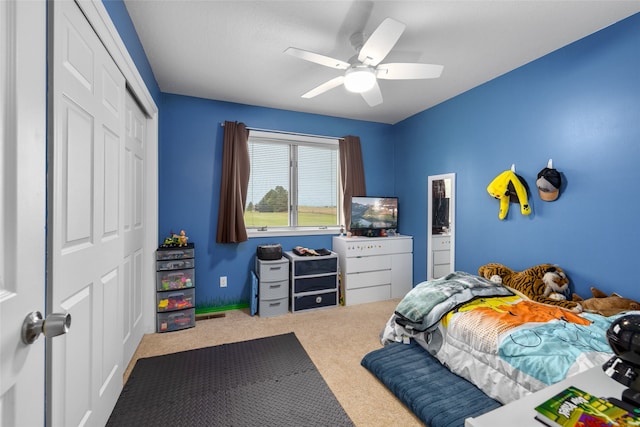 carpeted bedroom with ceiling fan and a closet