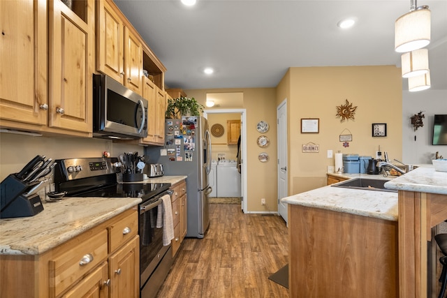 kitchen featuring light stone counters, stainless steel appliances, hardwood / wood-style flooring, sink, and decorative light fixtures