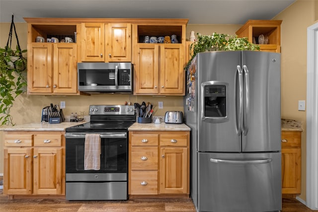 kitchen featuring light stone countertops, appliances with stainless steel finishes, and dark hardwood / wood-style flooring