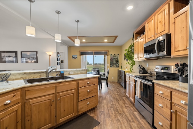 kitchen featuring sink, stainless steel appliances, hanging light fixtures, and dark hardwood / wood-style floors