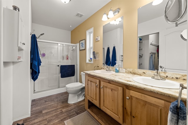 bathroom with vanity, hardwood / wood-style flooring, toilet, and an enclosed shower