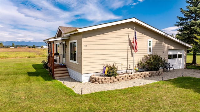 view of home's exterior with a mountain view and a yard