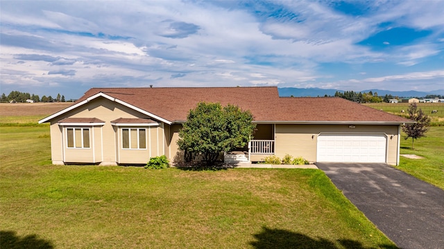 ranch-style house featuring a mountain view, a garage, and a front lawn