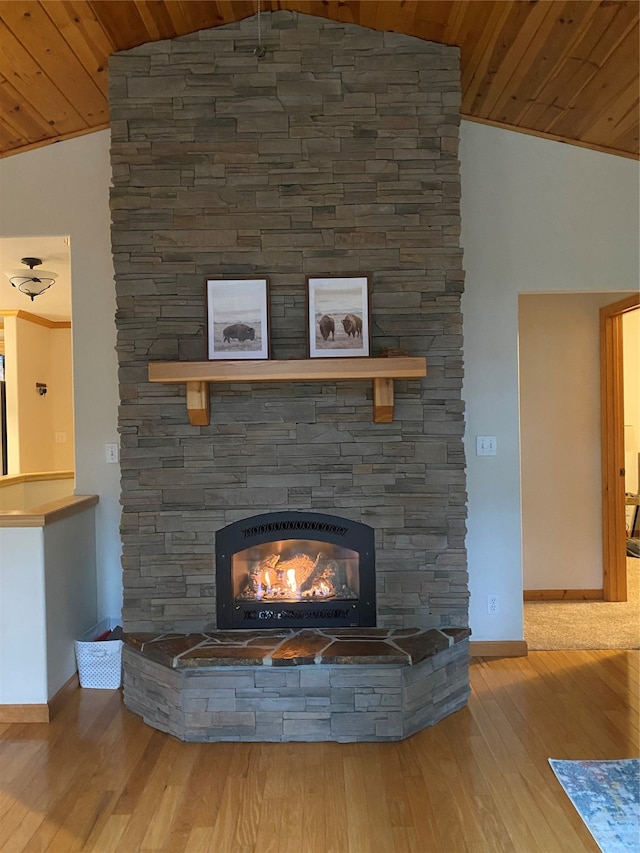 unfurnished living room featuring high vaulted ceiling, hardwood / wood-style flooring, a fireplace, and wooden ceiling