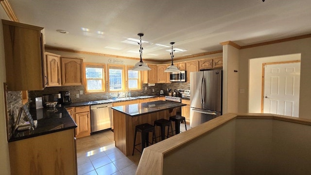 kitchen with a breakfast bar area, decorative light fixtures, tasteful backsplash, a center island, and stainless steel appliances