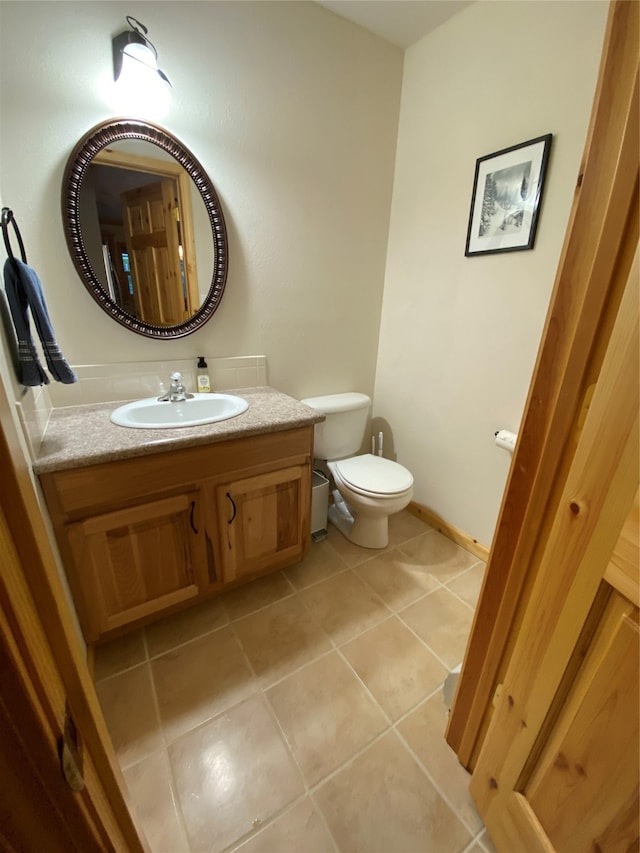 bathroom featuring tile patterned flooring, toilet, and vanity