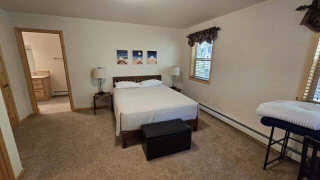 carpeted bedroom with baseboard heating and ensuite bath