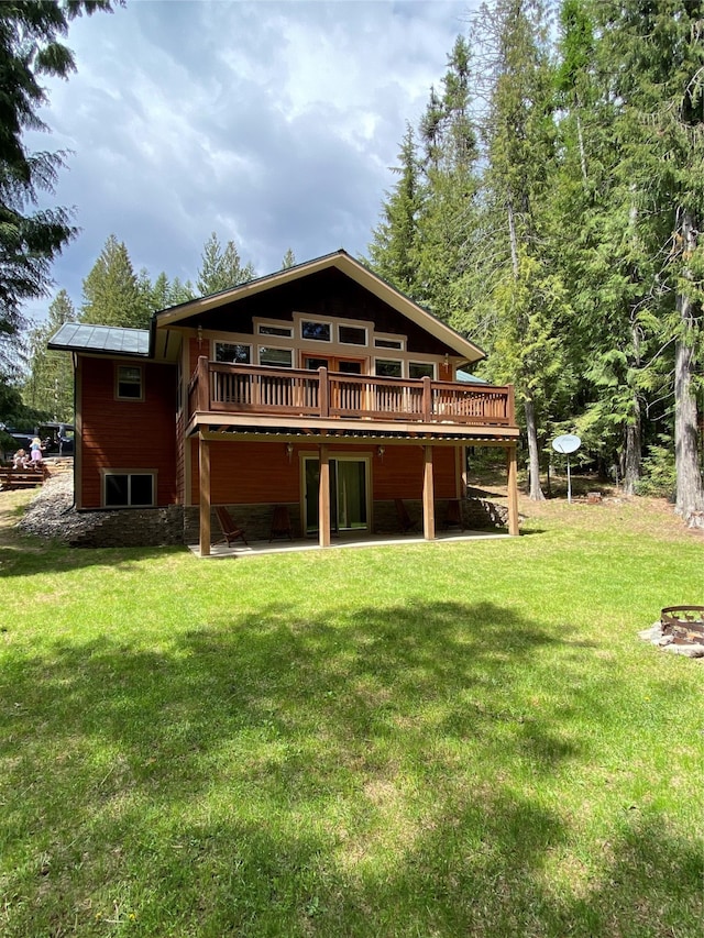 back of property featuring a deck and a lawn