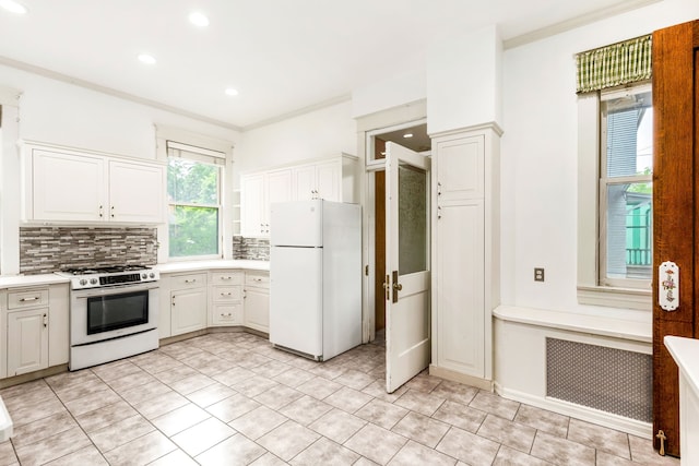 kitchen featuring white appliances, light tile patterned floors, tasteful backsplash, ornamental molding, and white cabinets