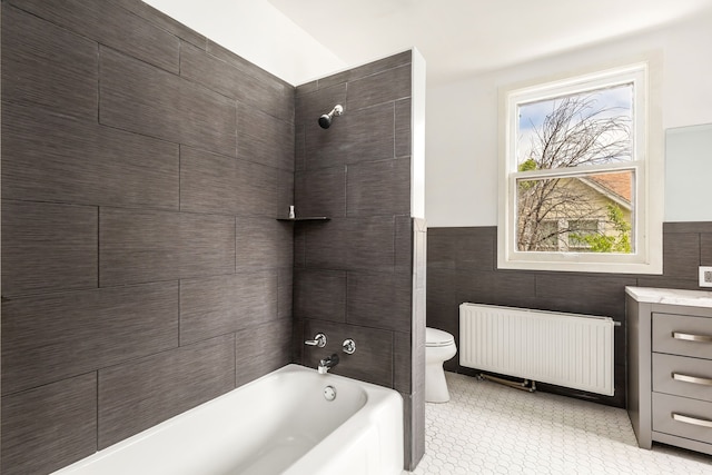 full bathroom with tile walls, toilet, radiator, and tiled shower / bath combo