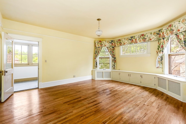 unfurnished room with radiator heating unit and wood-type flooring