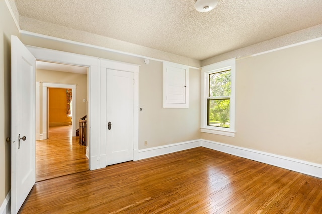 unfurnished bedroom with a textured ceiling and hardwood / wood-style floors