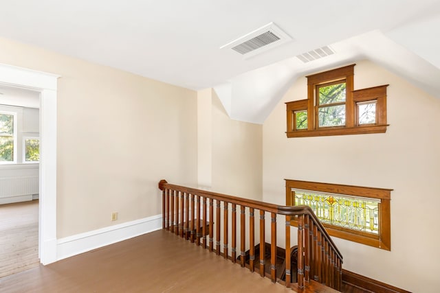 corridor with dark hardwood / wood-style flooring and lofted ceiling