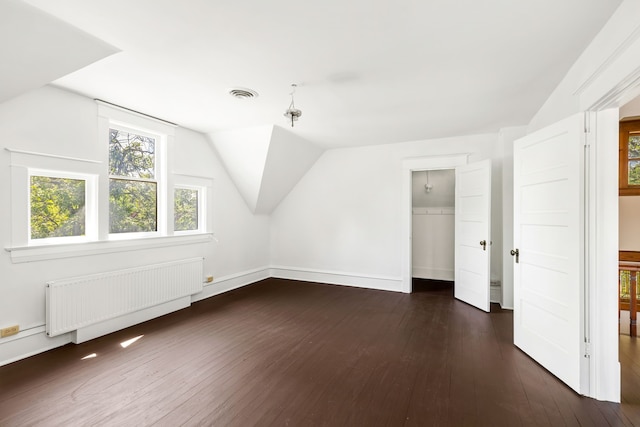 bonus room featuring lofted ceiling, radiator, and dark hardwood / wood-style floors