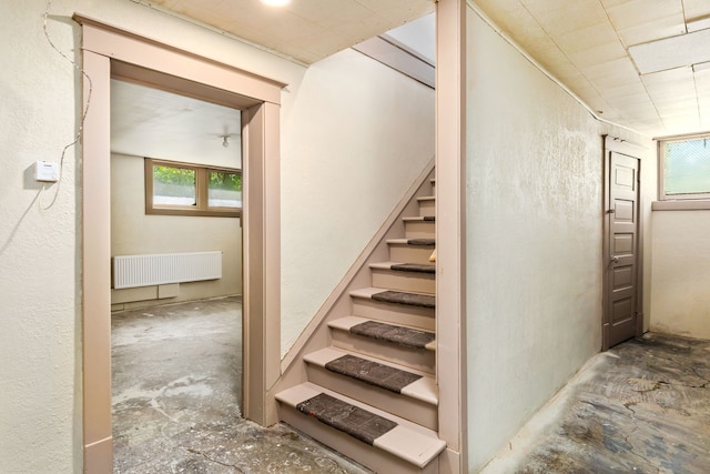 stairway with radiator and concrete flooring