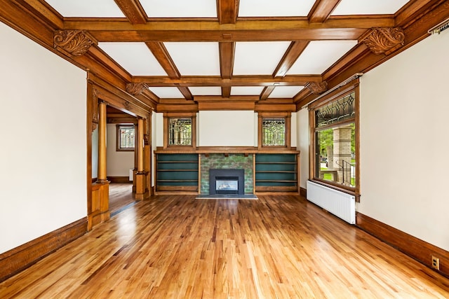 unfurnished living room with coffered ceiling, hardwood / wood-style flooring, radiator heating unit, and beamed ceiling