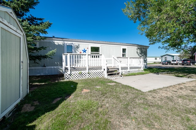 rear view of house featuring a yard, a patio, and a deck