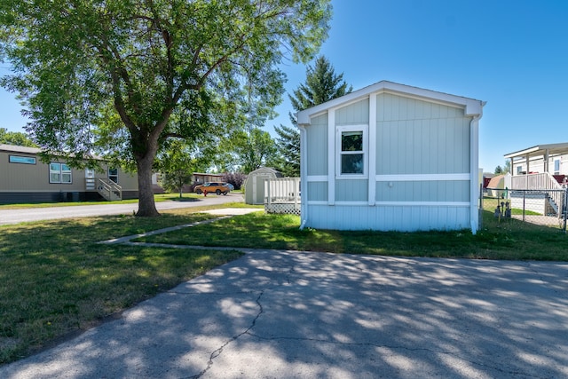 view of front of property with a front lawn and a shed